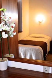 1 dormitorio con cama y espejo en Vilas Maria, en Funchal