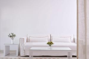 a living room with a white couch and white pillows at Grand Beach Hotel in Mikonos