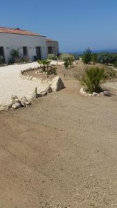 un cortile con rocce e un edificio nel deserto di Serra Niedda Resort & Agriturismo a Sorso