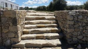 un muro di pietra con scala in pietra di Serra Niedda Resort & Agriturismo a Sorso