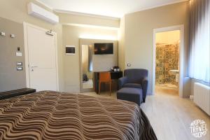 a bedroom with a bed and a chair and a desk at People Travel Rooms in Bologna