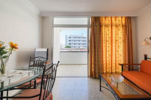 een woonkamer met een bank en een tafel met stoelen bij Apartamentos Amazonas in Playa del Inglés