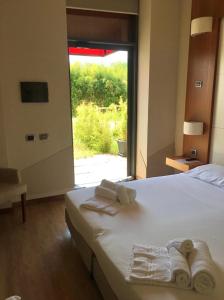 sypialnia z łóżkiem z ręcznikami i oknem w obiekcie Hotel Barrage w mieście Pinerolo