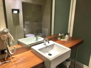 uma casa de banho com um lavatório e um espelho em Hotel Barrage em Pinerolo