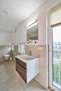 a bathroom with a sink and a toilet and a mirror at Scharhörn-Riff - 16 in Cuxhaven +18 photos