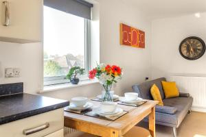 a kitchen and living room with a table with flowers on it at Leap Onyx Apartment - Northampton Town Centre in Northampton