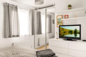 una camera da letto con TV su un comò bianco di Leap Onyx Apartment - Northampton Town Centre a Northampton