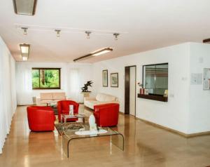 Una sala de estar con sillas rojas y un sofá. en Ferienwohnung mit Garten und Pool in Ascona, en Ascona