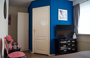 een slaapkamer met blauwe muren en een witte deur bij The Studio Guesthouse in Volendam