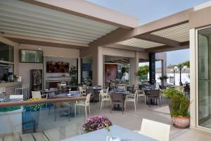 a restaurant with tables and chairs on a patio at Oscar Suites & Village in Agia Marina Nea Kydonias