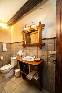 a bathroom with a sink and a toilet and a mirror at Posada Elbete in Elbete