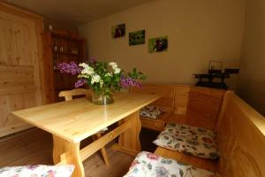 een kamer met een houten tafel en een vaas met bloemen bij Ferienwohnungen Kleiner Kuhstall in Kurort Gohrisch