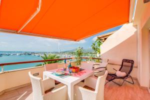 a table and chairs on a balcony with a view of the water at Ideal Property Mallorca - Blue Attic Beach in Alcudia
