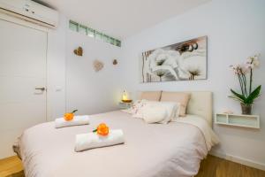 a bedroom with a white bed with orange flowers on it at Ideal Property Mallorca - Blue Attic Beach in Alcudia
