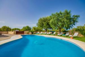 a large swimming pool with chairs and trees at Ideal Property Mallorca - Vernissa in Santa Margalida