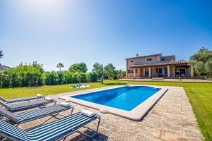 a villa with a swimming pool and two lounge chairs at Ideal Property Mallorca - Ses Poves in Alcudia
