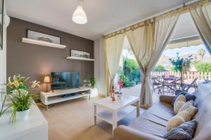 un salon avec un canapé et une télévision dans l'établissement Ideal Property Mallorca - Taronger, à Alcúdia