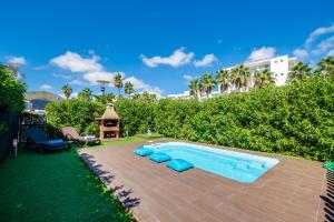 - une piscine avec des chaises longues bleues à côté d'un complexe dans l'établissement Ideal Property Mallorca - Taronger, à Alcúdia