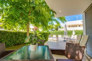 d'une terrasse avec une table, des chaises et un arbre. dans l'établissement Casa Francina, à Playa de Muro