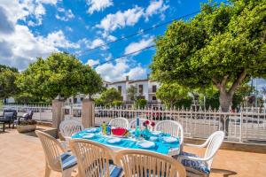 uma mesa e cadeiras num pátio com uma cerca em Ideal Property Mallorca - Villa Celia em Port d'Alcudia