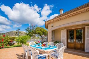 una mesa y sillas en un patio en Ideal Property Mallorca - Villa Celia en Port d'Alcudia