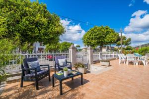 patio z 2 krzesłami i stołem w obiekcie Ideal Property Mallorca - Villa Celia w Port d'Alcudia