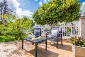 eine Terrasse mit 2 Stühlen und einem Tisch in der Unterkunft Ideal Property Mallorca - Villa Celia in Port d'Alcúdia