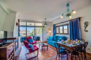 a living room with a blue couch and a table at Angelo in Can Picafort