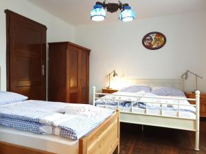 a bedroom with two twin beds and a clock on the wall at Chalupa Pomněnka in Jáchymov