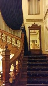 una escalera con una cortina azul y un espejo en Grand Boutique Hotel, en Bucarest