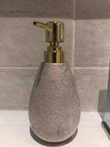 a metal soap dispenser sitting on top of a counter at Entire Whalley House in Burnley