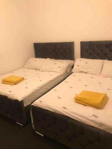 2 Betten in einem Zimmer mit gelben Handtüchern darauf in der Unterkunft Entire Whalley House in Burnley