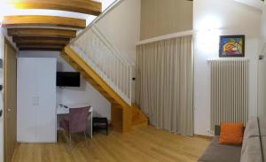 a living room with a staircase and a table at La Baita D'Oro Ristorante Residence in Monteduro