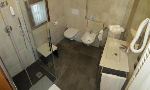 a bathroom with a toilet and a sink and a shower at La Baita D'Oro Ristorante Residence in Monteduro