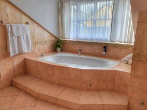 y baño con bañera y ventana. en Penzion Gemer, en Jeseník