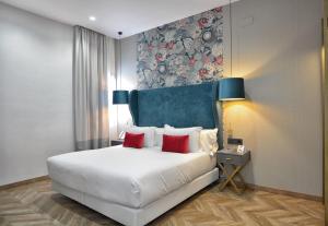 1 dormitorio con 1 cama blanca grande con almohadas rojas en Soho Boutique Sevilla, en Sevilla