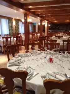 a dining room with white tables and chairs with glasses at Hotel Soldeu Maistre in Soldeu +22 photos