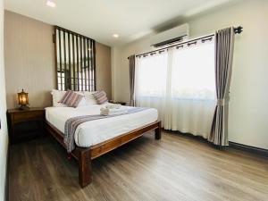 um quarto com uma cama e uma grande janela em C Hotel Boutique and Comfort em Chiang Mai