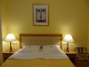 ein Schlafzimmer mit einem Bett mit zwei Lampen auf beiden Seiten in der Unterkunft Residence Parliament in Budapest