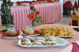 a table with plates of food on a pink table at Hotel Belmare in Marciana