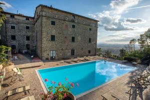 a blue and white swimming pool in front of a house at Villa Schiatti in Cortona