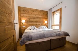um quarto com uma cama e uma parede de madeira em Résidence Androsace du Lyret em Chamonix-Mont-Blanc