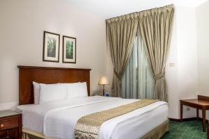 
a hotel room with a large bed and a large window at Days Inn Hotel & Suites Amman in Amman
