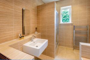 a bathroom with a white sink and a window at The Kings Head Country Hotel in King's Lynn