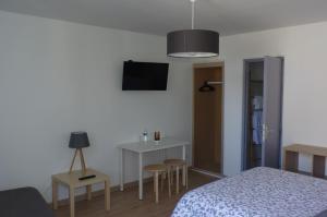 a bedroom with a bed and a table and chairs at Hôtel L'Arbousier in Soulac-sur-Mer