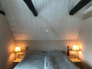 uma cama num quarto com duas lâmpadas nas mesas em Botanikerns hus em Löderup