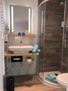 a bathroom with a sink and a shower at Gästehaus am Elberadweg by Hotel Alte Fischerkate in Mödlich