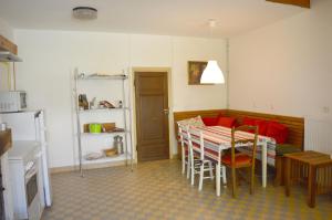 eine Küche und ein Esszimmer mit einem Tisch und einem Sofa in der Unterkunft La petite maison in Grancey-le-Château