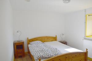 Schlafzimmer mit einem Holzbett und einem Spiegel in der Unterkunft La petite maison in Grancey-le-Château