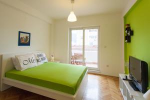 Dormitorio verde con cama y TV en Apartment Partizanska, en Ohrid